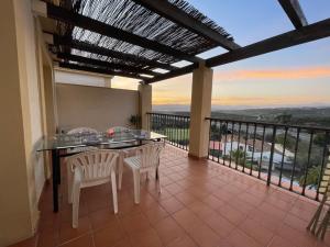 patio con mesa y sillas en el balcón en Atico Baviera Golf-Playa, en Caleta de Vélez