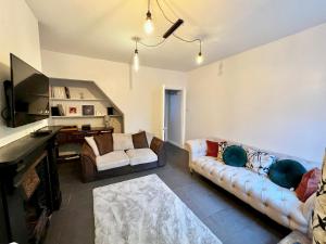 a living room with two couches and a television at The secret garden house in Lincolnshire