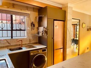 a kitchen with a sink and a dishwasher at Mndazi Manor in Pimville