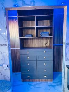 einen blauen Schrank mit einer Kommode in einem Zimmer in der Unterkunft Mndazi Manor in Pimville