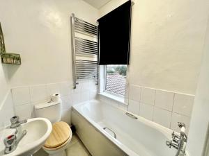 a bathroom with a tub and a sink and a toilet at The secret garden house in Lincolnshire