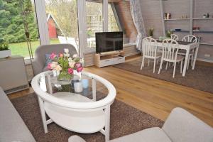 een woonkamer met een tv en een tafel met bloemen bij Zeltdachhaus _ Renovierung 2019 _ in Damp