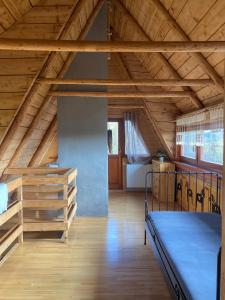 a large room with a bed and wooden ceilings at Istebna Pełna chata in Istebna