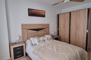 ein Schlafzimmer mit einem großen Bett mit zwei Nachttischen in der Unterkunft Piso Puerta del Ángel in Jaén