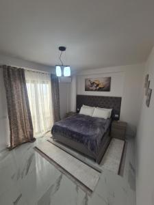 um quarto com uma cama e uma janela em Elite1 5C em Saranda