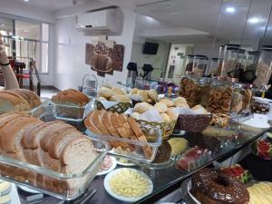 a buffet filled with different types of bread and pastries at Serra Linda Hotel in Serra