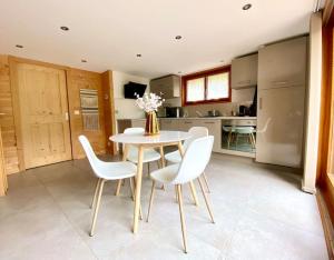 une salle à manger avec une table et des chaises ainsi qu'une cuisine dans l'établissement Androsace Appartement dans Chalet bois avec Jacuzzi privatif Terrasse et Vue Montagne, à Les Villards-sur-Thônes