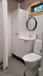 a white bathroom with a toilet and a mirror at SiikaVilla, Siikajoki in Siikajoki