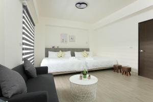 een witte slaapkamer met een bed en een bank bij Peng Together B&B in Magong