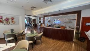 restauracja ze stołami i krzesłami oraz bar w obiekcie Al Maha Int Hotel Oman w Maskacie