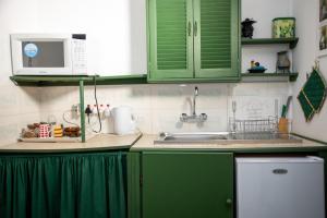a kitchen with green cabinets and a sink at The Cottage in Rustenburg