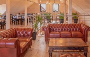 ein Wohnzimmer mit Ledersofas und einem Tisch in der Unterkunft Nice Home In Jezierzany With Sauna in Jezierzany
