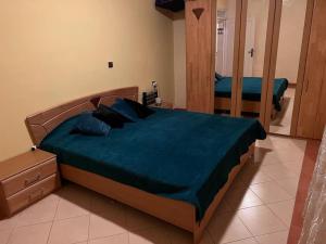 een slaapkamer met een bed met blauwe lakens en een spiegel bij 3 Zimmer Wohnung Corniche Nador Sidi Ali- am Meer & Wifi in Nador