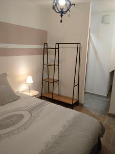 リル・シュル・ラ・ソルギュにあるLa Sorguetteのベッドルーム(ベッド1台、ランプ、鏡付)