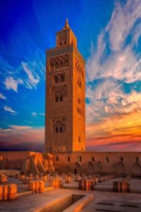 un gran edificio con una torre de reloj al atardecer en Rayan Tours, en Fkih Ben Salah