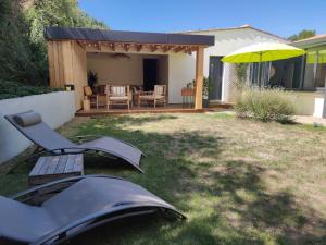 a backyard with a table and an umbrella at Chambre avec entrée indépendante in Esnandes