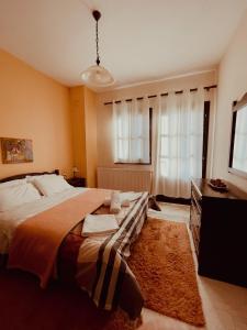 a bedroom with a large bed and a dresser at Muses Apartments in Pisoderi