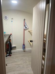 an open door to a room with a broom at Brook Cottage in Holmfirth +40 photos