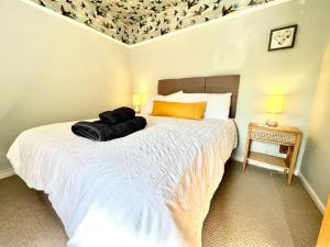 a bedroom with a large white bed in a room at Penny Black Cottage in Lavenham