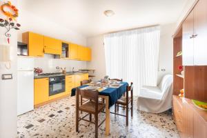 cocina con mesa de comedor y armarios amarillos en Edera 3 Silvi Vacanza, en Silvi Marina
