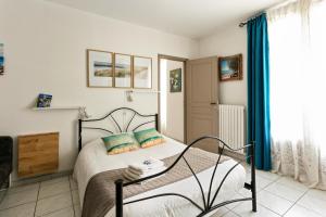 a bedroom with a bed with blue curtains at La Clé d'Or in Servian