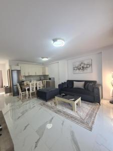 uma sala de estar com um sofá e uma mesa em Elite1 5C em Saranda