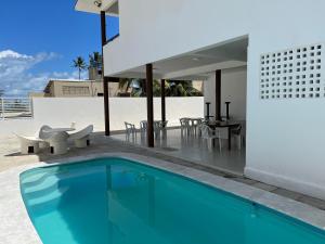 ein Haus mit einem Pool und einem Essbereich in der Unterkunft Casa em FRENTE À PRAIA, ao lado do Nord Hotel - Tabatinga in Conde
