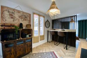 uma sala de estar com uma mesa e um bar em L'Expédition BEST KEYS - Centre Ville - Netflix em Villeneuve-sur-Yonne