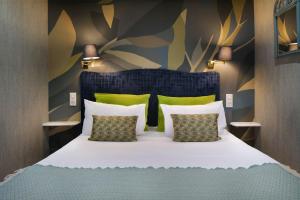 a bedroom with a large bed with two pillows at Hotel de France in Saint-Vaast-la-Hougue