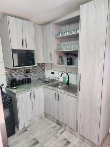 a kitchen with white cabinets and a sink at SiBella guest house in Bloemfontein