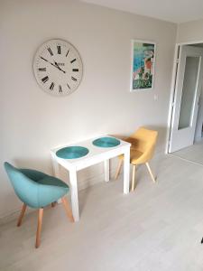 um quarto com uma mesa e duas cadeiras e um relógio em T2 plage de sable à 300m+ parking gratuit em Bandol