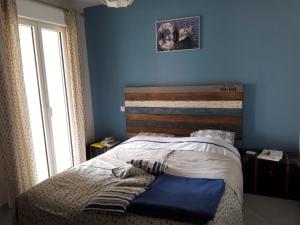 sypialnia z łóżkiem z niebieską ścianą w obiekcie MONTICELLO - L'ÎLE-ROUSSE APPARTEMENT BORD DE MER 3 Pièces 4 Personnes w mieście Monticello