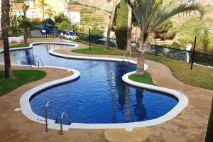 una piscina en un parque con palmeras en Casa de la Suerte en Almuñécar