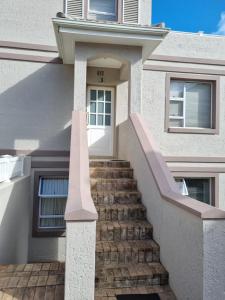 a house with stairs leading to a white door at Pincushion Place Pinnacle Point Mosselbay South Africa in Mossel Bay
