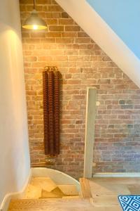 a room with a brick wall and a heater at Station Masters Cottage in Hope