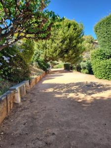 a tree lined road with a fence and trees at T2 plage de sable à 300m+ parking gratuit in Bandol