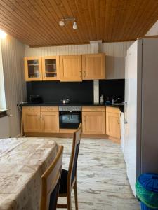 a kitchen with wooden cabinets and a table with chairs at Monteurzimmer Ahnetal Zweibettzimmer Einzelzimmer mit eigenem Bad in Dörnberg +16 photos