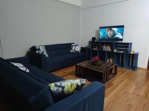 een woonkamer met twee blauwe banken en een tv bij Departamento 101 La Santisima in Mexico-Stad