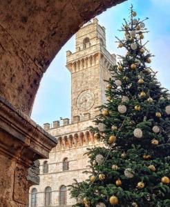 un albero di Natale davanti a un palazzo con una torre dell'orologio di Casa Matilde a Montepulciano