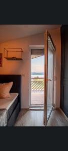 a bedroom with a window and a bed and a door at Ferienhaus Vienna REM in Prokosovići