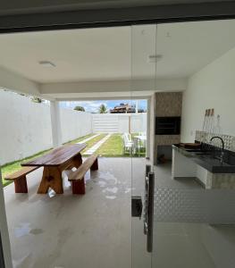 a kitchen with a wooden bench and a table at Casa inteira em C Vermelha in Porto Seguro