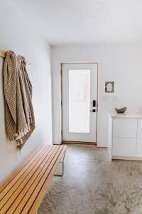 a white room with a bench and a door at Okt Häus in Nordegg
