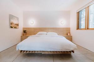 a bedroom with a large bed in a white room at Okt Häus in Nordegg