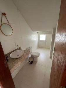 uma casa de banho com um lavatório e um WC em Casa inteira em C Vermelha em Porto Seguro