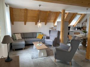 een woonkamer met een bank, stoelen en een tafel bij SEENLANDHOF in Senftenberg