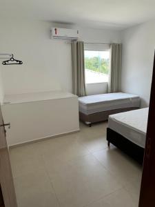 1 Schlafzimmer mit 2 Betten und einem Fenster in der Unterkunft Casa inteira em C Vermelha in Porto Seguro