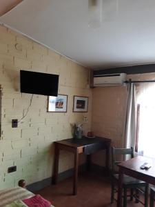 Habitación con mesa y TV en la pared. en La Tranquera Alquiler Temporario en Cafayate