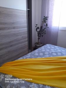 - une chambre avec une couverture jaune sur un lit dans l'établissement Emi2, à Crikvenica