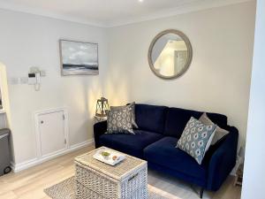a living room with a blue couch and a mirror at The Little Snug in St Ives in St Ives