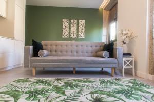 kanapa w salonie z zieloną ścianą w obiekcie Birds Apartments w Porto